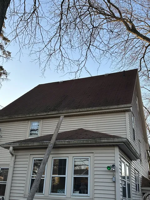 Weathered roof shingles before storm damage repair