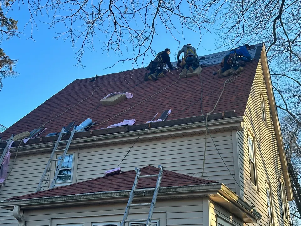 Ultra Roof LLC crew installing new shingles on a two-story Milwaukee home