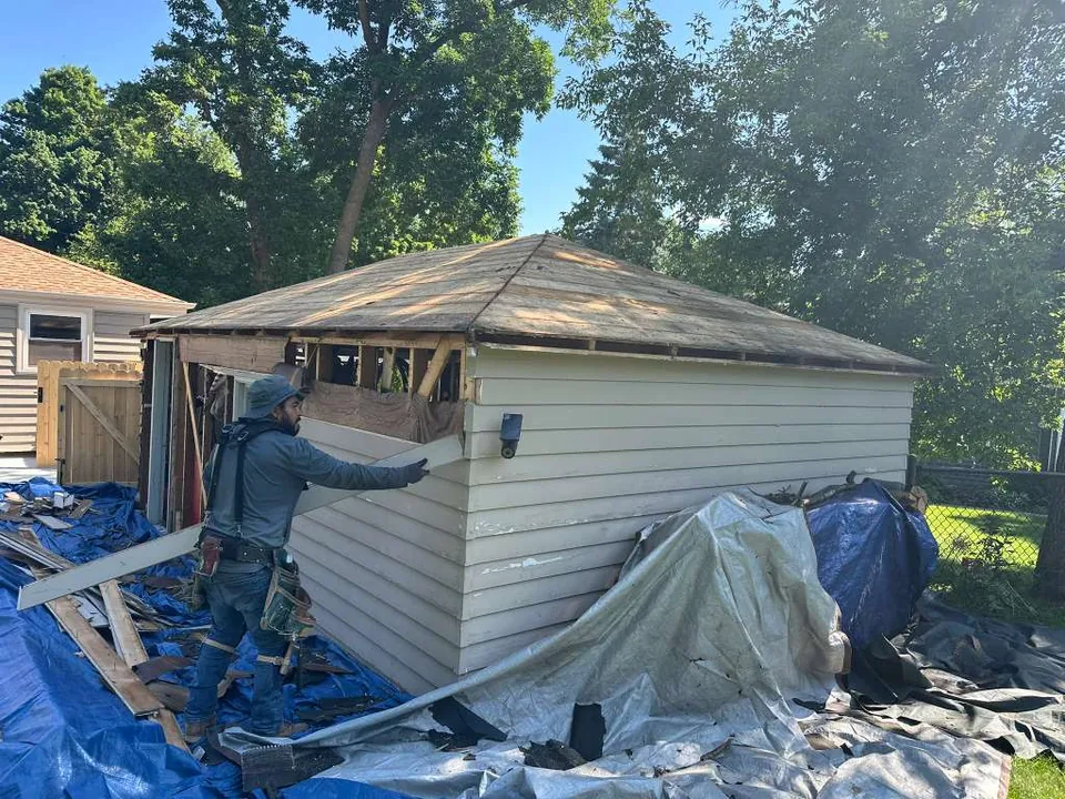 An Ultra Roof LLC crew member installing new siding on a garage