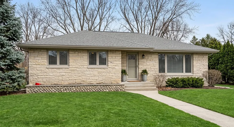 A completed roof replacement on a stone ranch home